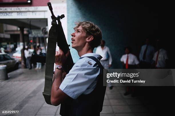 South African police officer stands on alert in the streets of Johannesburg anticipating a riot.