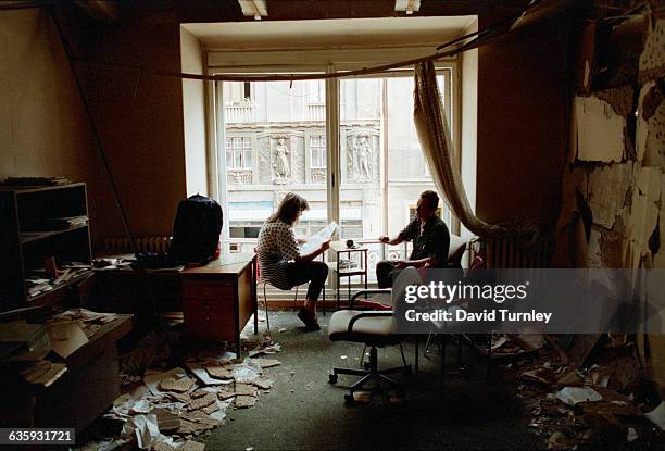 Bosnian couple reads the newspaper in their bombed-out apartment along Marshal Tito Avenue in Sarajevo.