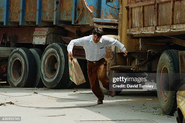 Bosnian man dashes across a Sarajevo street where many civilians have been hit by sniper fire.