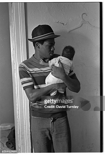 Father holds his baby in his home in Detroit's Poletown neighborhood. The ethnically-diverse, working class neighborhood is being razed to make room...
