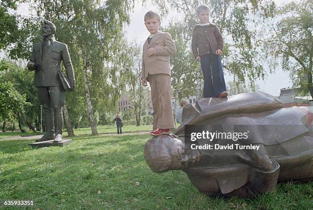 Children Standing on a Fallen Statue of Stalin