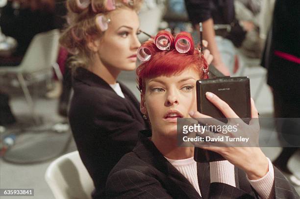Fashion model Linda Evangelista prepares for a fashion show at the Musee du Louvre in Paris, France. Visible in the background is model Karen Mulder,...