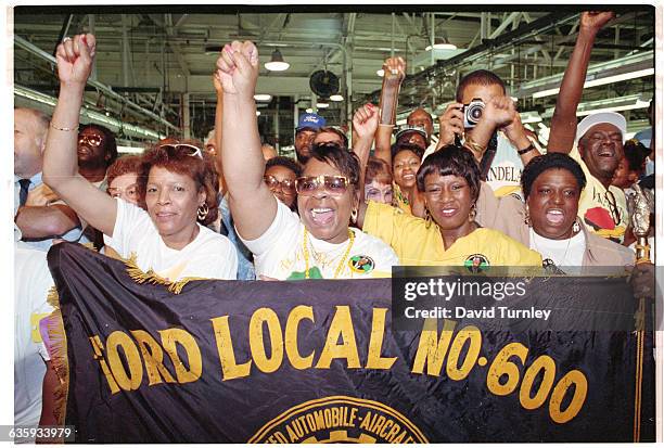 Members of an auto workers' union in Detroit hold a banner and raise their fists to welcome Nelson Mandela, the anti-apartheid activist recently...