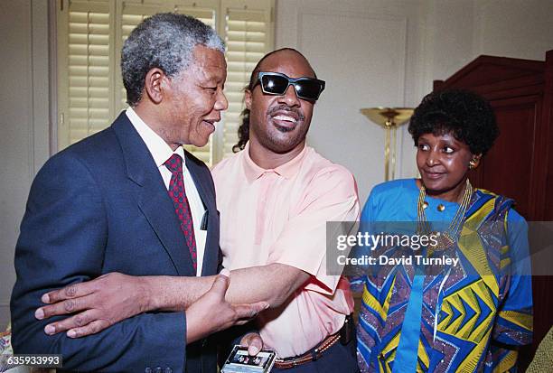 Anti-apartheid activist Nelson Mandela greets singer Stevie Wonder as Mandela's wife, Winnie, looks on. Mandela is touring the United States...