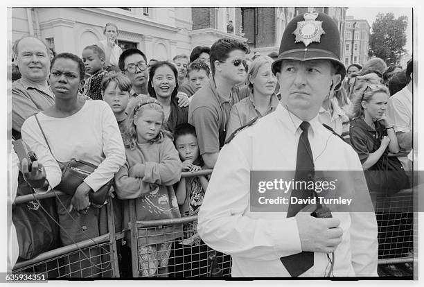 London Bobby stands in front of a crowd watching a parade at the Notting Hill Carnival.