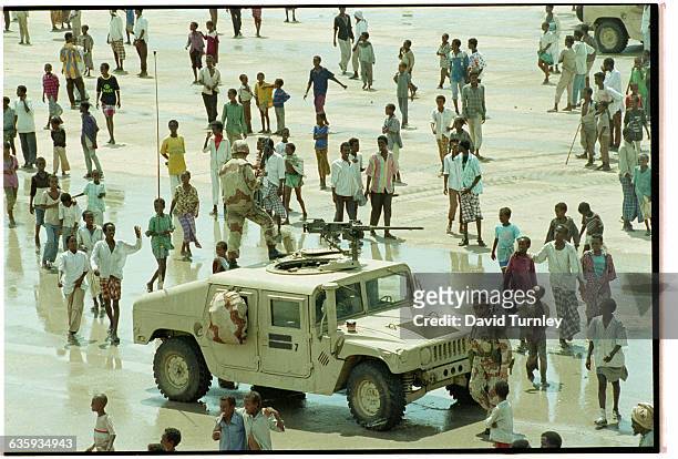 Group of Somalis gather around a US Marine humvee in an open space in Mogadishu.