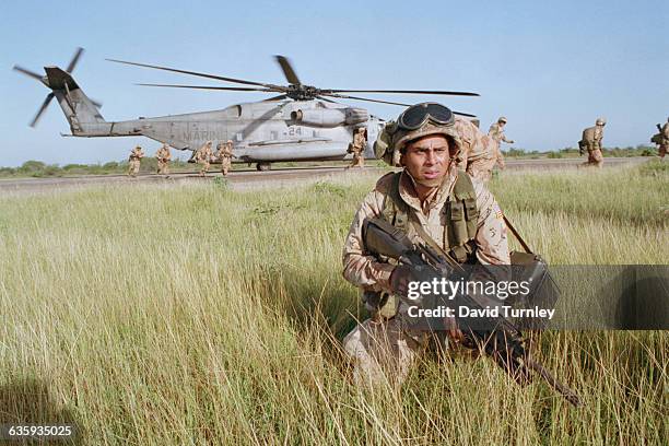 Marine stays alert as a helicopter lands in Mogadishu during Operation Restore Hope.