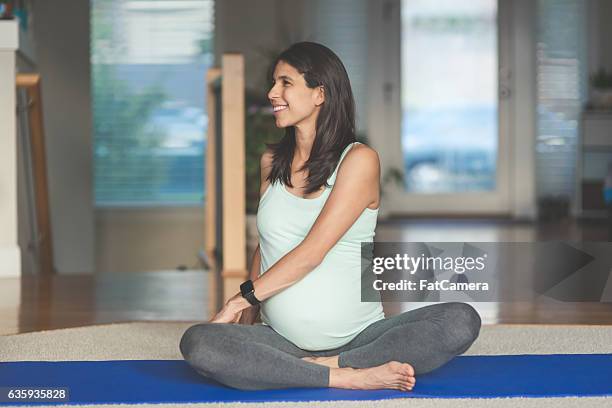 ethnic pregnant mother doing yoga in the home - prenatal yoga stock pictures, royalty-free photos & images