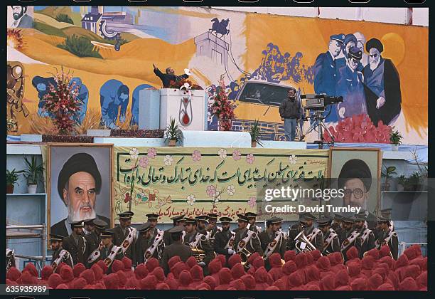 Speaker on the podium at a rally commemorating the 14th anniversary of the Iranian Revolution.