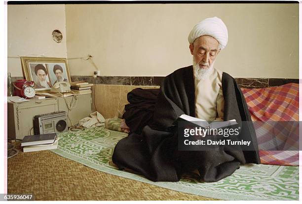Shiite Muslim man studies a book in the town of Qom, which is a center of Shiism. Pictures of the late Ayatollah Khomeini and the current Ayatollah...