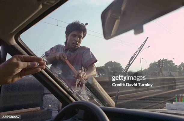 Immigrant Washing a Car's Windshield