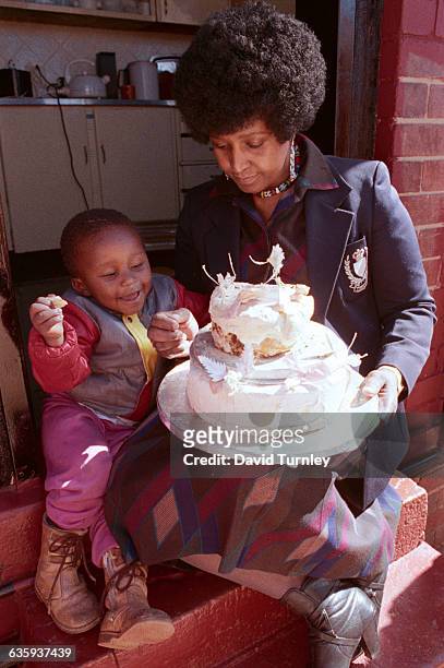 Winnie Mandela shows part of her wedding cake to her grandson. The wife of jailed anti-apartheid activist Nelson Mandela, she has saved the cake for...