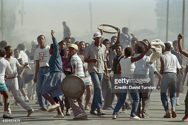 High school students riot in a Soweto street near Winnie Mandela's house protesting apartheid.