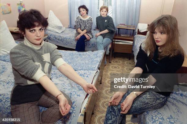 Two young women at a rehabilitation center show their bruised and tracked forearms from intravenous drug use.