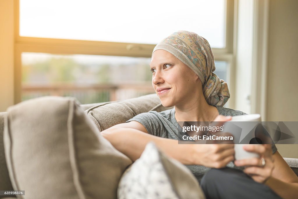 Ethnic young adult female cancer patient sipping tea