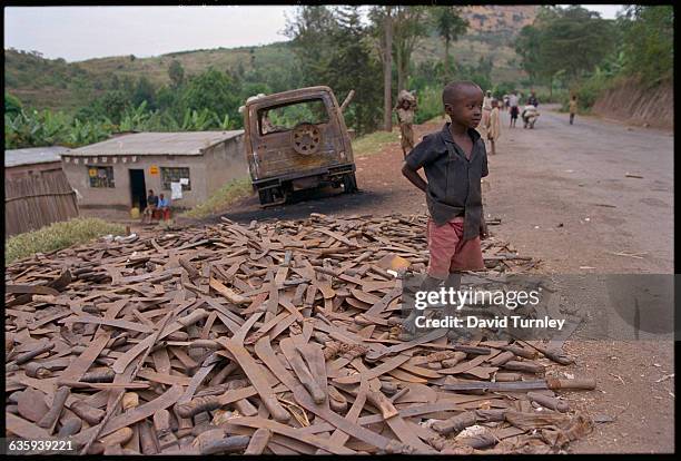 Boy Standing on Pile of Machetes