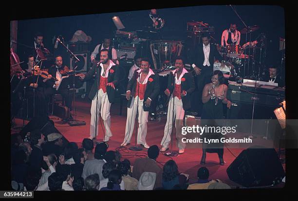 Picture shows an aerial view of the soul singing group, Gladys Knight & the Pips, performing on stage in concert.