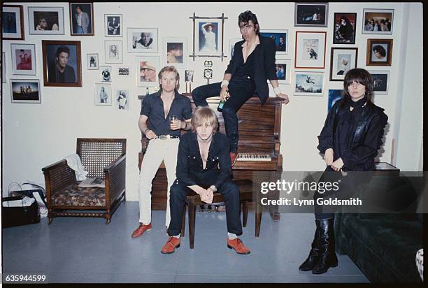 The Pretenders in a photographer's studio. From left, they are Martin Chambers, James Honeyman-Scott, Peter Farndon sitting on top of the piano, and...