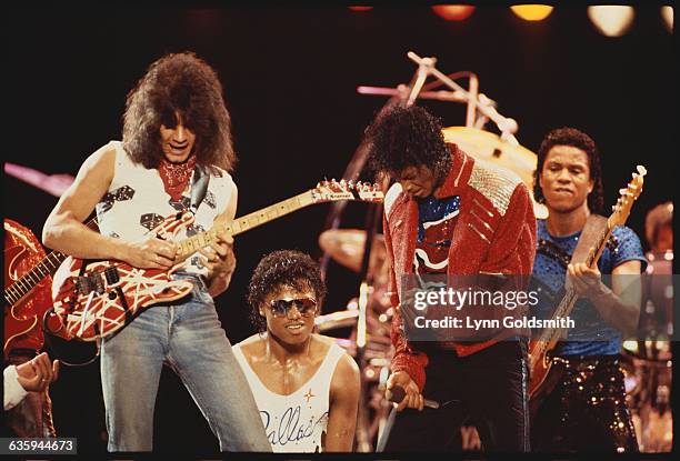 Eddie Van Halen plays guitar on stage with Randy Jackson, Michael Jackson and Jermaine Jackson during the Victory Tour.