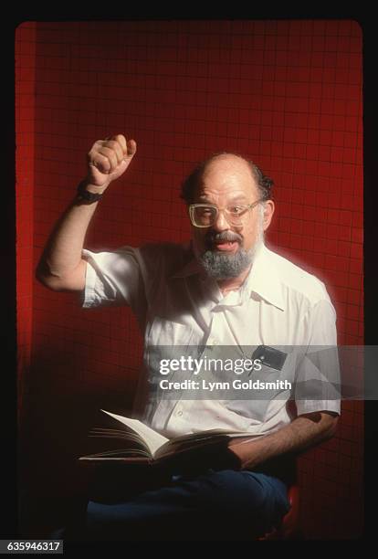 Beat poet Allen Ginsberg reads from a book.