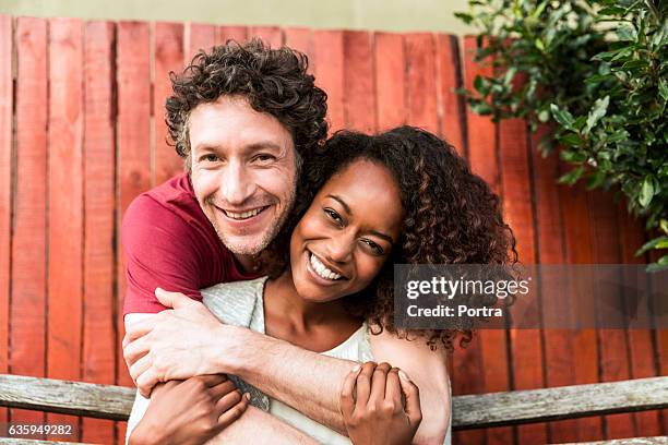 happy man embracing woman at yard - black couple date stockfoto's en -beelden