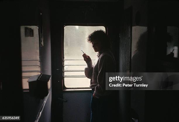 Young woman looks out the window of a train headed from Tallinn to Vilnius. | Location: Between Tallinn, Estonia, and Vilnius, Lithuania, USSR.