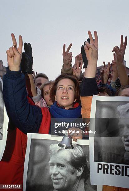 Czechoslovakian student rings a bell and holds a poster of Vaclav Havel during the Velvet Revolution in Prague.
