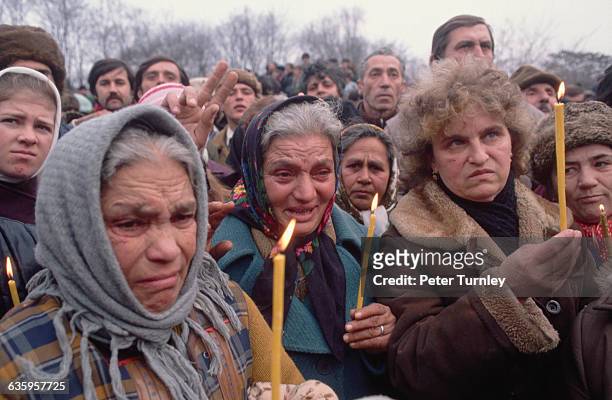 Elderly Bucharest women weep with visible emotion as they stand among the crowd at a pro-revolutionary demonstration during the revolution of...