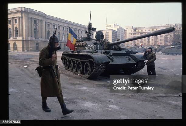 Soldiers keep watch and man tanks in a square in Bucharest during the revolution of December 1989.