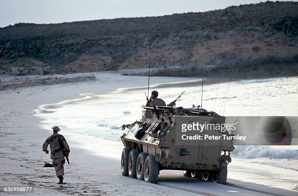 United States Marines drive a personnel carrier along the shoreline after making an amphibious landing on a Somali beach in December of 1992. In the...