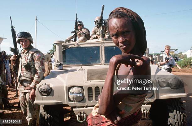 Somali woman stands near a military vehicle and US soldiers during "Operation Restore Hope." In the 1980s a civil war in Somalia began when warlord...