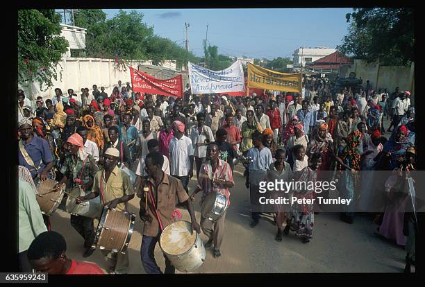 Somalis carry banners and beat drums during a peace demonstration in front of General Mohammed Farah Aideed's house to welcome the arriving troops....