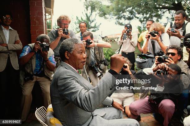 Nelson Mandela raises a fist for portraits by photojournalists covering his homecoming after he was released from prison.