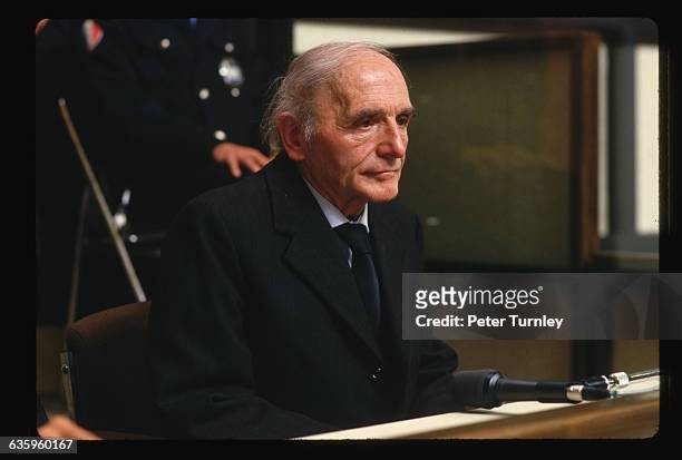 Former Gestapo officer Klaus Barbie sits behind a glass screen before the Lyon Assize court at the opening of his trial. Barbie is accused of crimes...