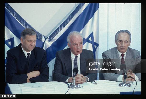 Norwegian Foreign Minister Johan Jorgen Holst, left, facilitates the signing of the peace agreement between Israel and the Palestine Liberation...
