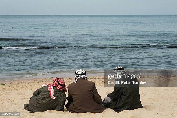 Men Wearing Kaffiyehs Sitting on Beach