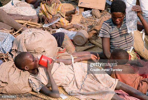 Rwandan man cares for one of the thousands of refugees who fled the war in Rwanda and then fell victim to a cholera epidemic in a refugee camp in...