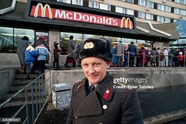 Soviet policeman stands by a queue of people waiting to enter a newly opened McDonald's on Gorky Street in Moscow in 1990.