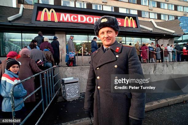Soviet policeman stands by a queue of people waiting to enter a newly opened McDonald's on Gorky Street in Moscow in 1990.