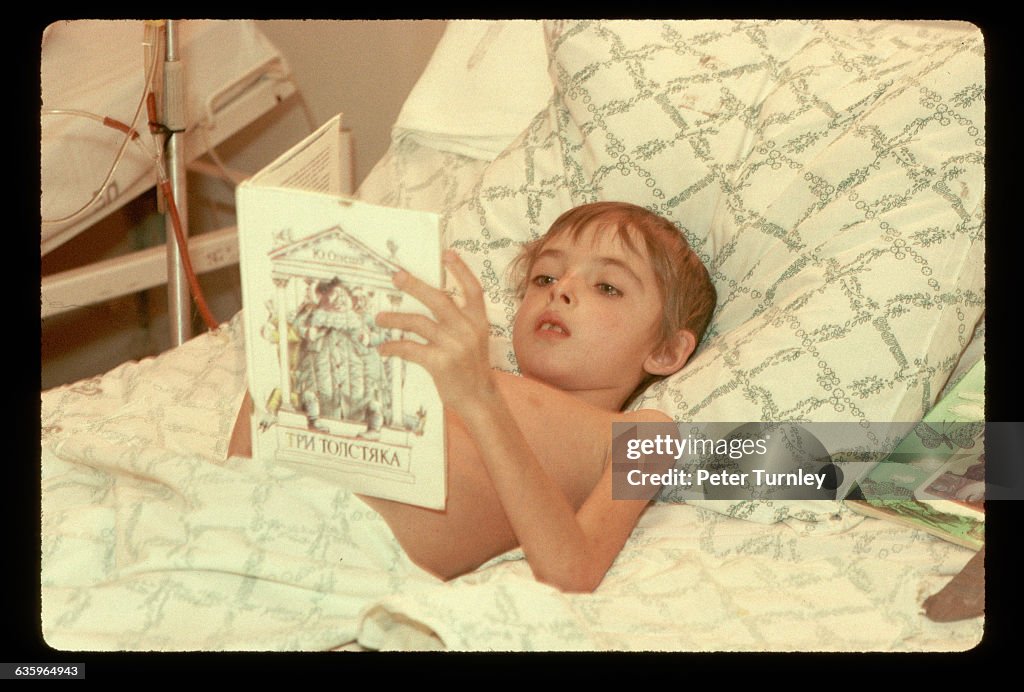 Boy Reading in a Hospital Bed