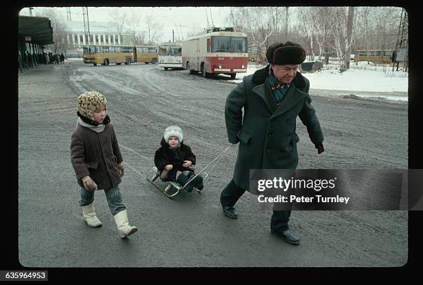 Man Pulling Children on a Sled