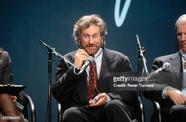 Movie Director/Producer Steven Spielberg plays with the headphones of his real-time translation receiver at the opening of the Polish version of his...
