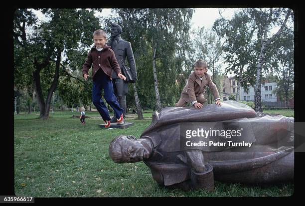 After the coup, children play on a toppled statue of Stalin.