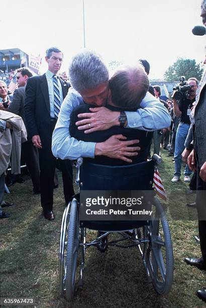 Democratic presidential nominee Bill Clinton hugs Max Cleland, a disabled Vietnam veteran and the secretary of state of Georgia, during a 1992...