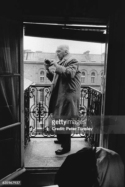 Photographer Andre Kertesz stands on an apartment balcony on Ile de la Cite.