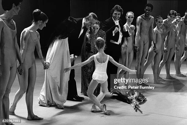 During a curtain call for Martha Graham and her dancers, a young ballerina curtsys for Graham and Halston.