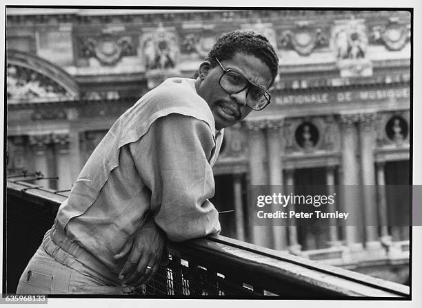 Jazz musician Herbie Hancock leans on a railing with a view of the Paris Opera House below.