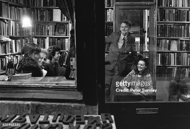 George Whitman at a meeting in a room lined with bookshelves at the Shakespeare and Company Bookstore which he owns.