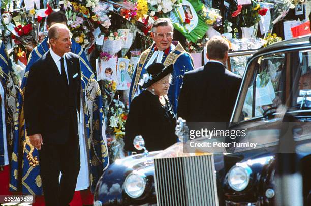 Philip, Duke of Edinburgh stands behind Elizabeth, The Queen Mother as she gets into an automobile at the funeral of Diana, Princess of Wales, only...