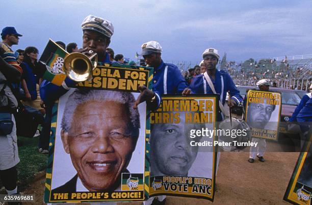 Campaign workers play music and carry posters of Mandela. They also carry posters in memory of the late Chris Hani, who was assassinated in 1993.